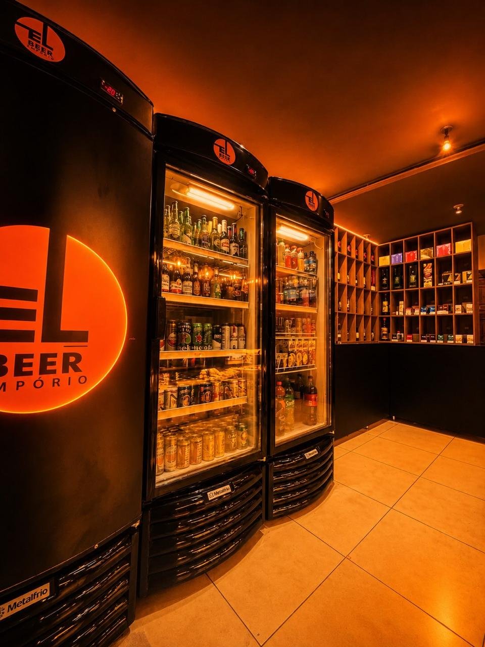 Freezers do El Beer cheios de cerveja em garrafa e lata, com o letreiro laranja aceso na parede
